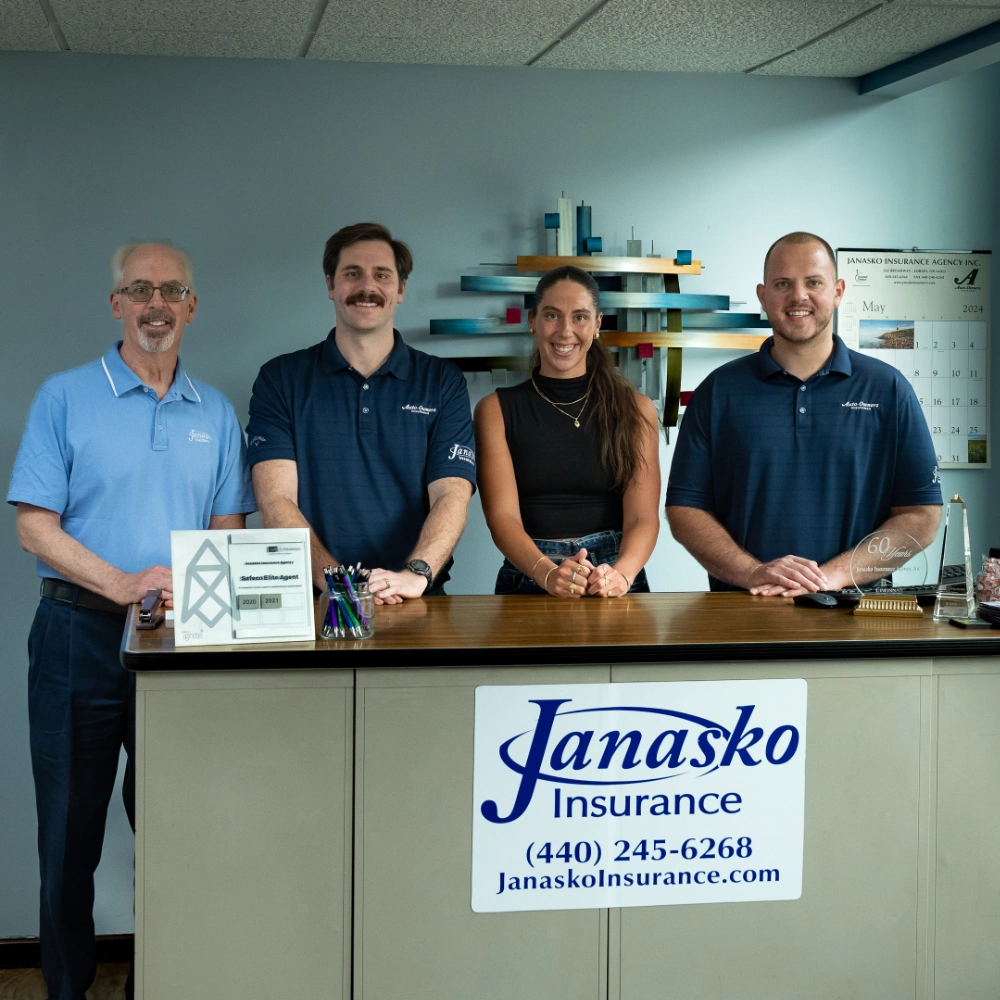 The Janasko team poses together, smiling, in a professional setting, showcasing collaboration and teamwork.